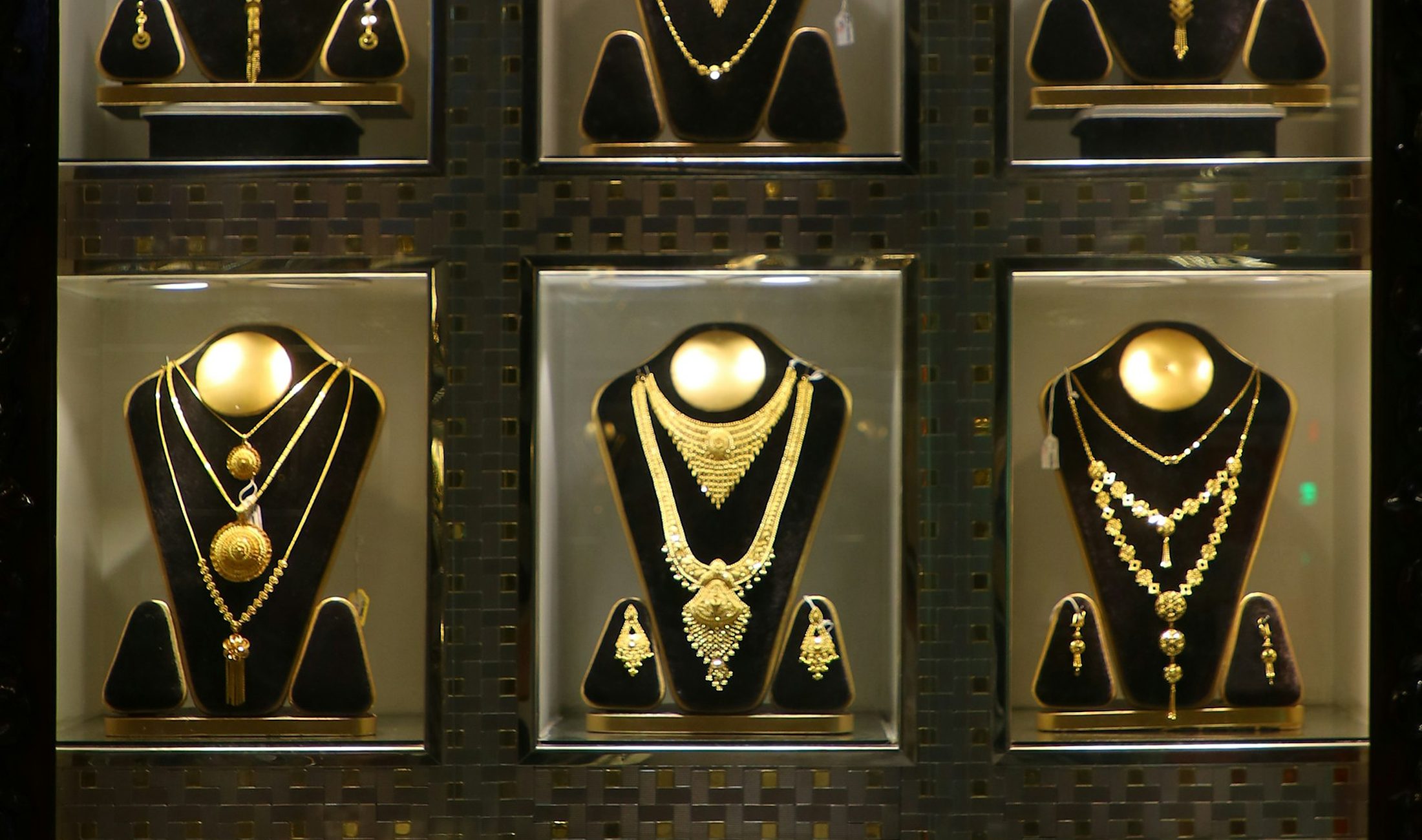 Gold necklace sets in a lit display case